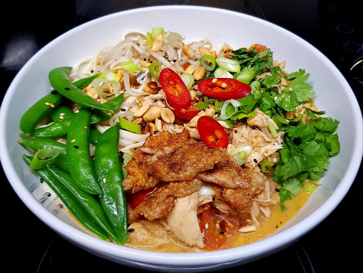 A Very Simple Coconut Noodle Soup with Chicken and Snap Peas and Finished with Herbs and Nuts. Crispy Chicken Skin for Crunch.