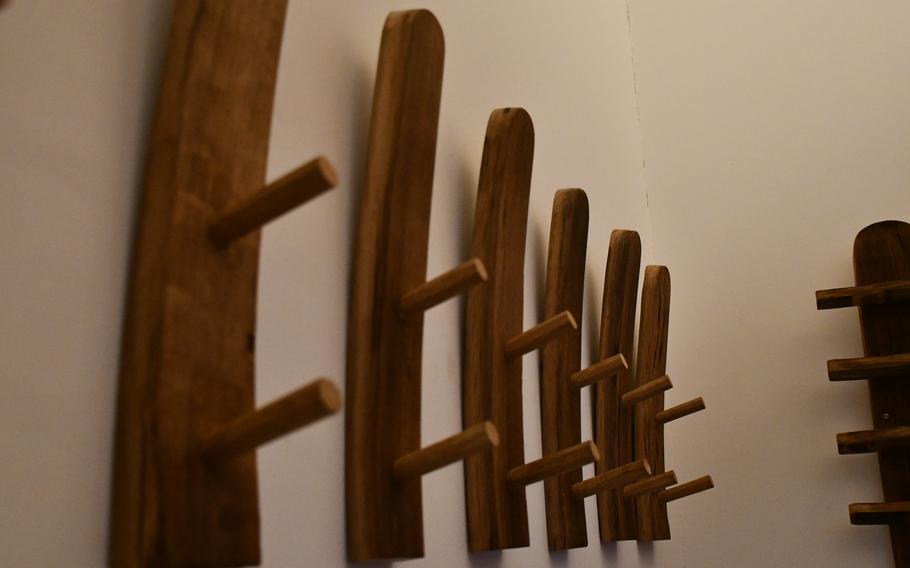 A close-up detail of wooden hooks on a white wall in the sauna area of the Südpfalz Therme.