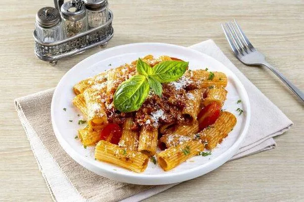 Classic italian pasta penne alla arrabiata with basil and freshly grated parmesan cheese.