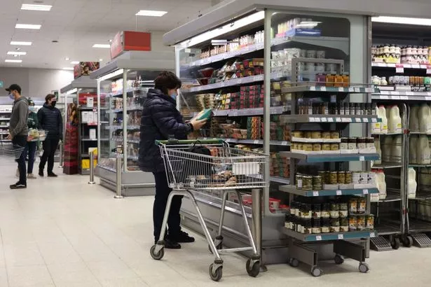 A woman shops for food at a Waitrose supermarket