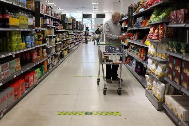 A man shops at a Waitrose supermarket in London