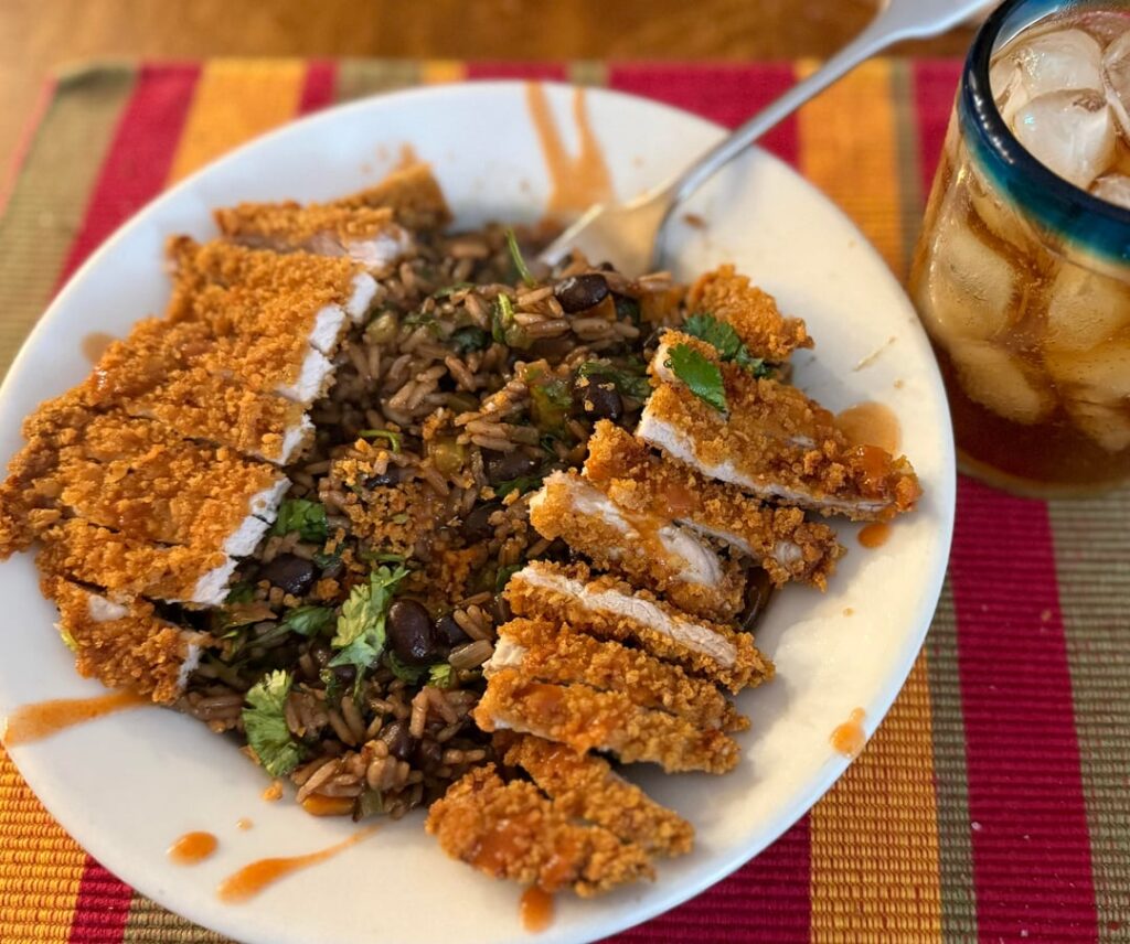 Pork cutlet & Cuban rice with a few dashes of Frank’s hot sauce (and a rum & coke)