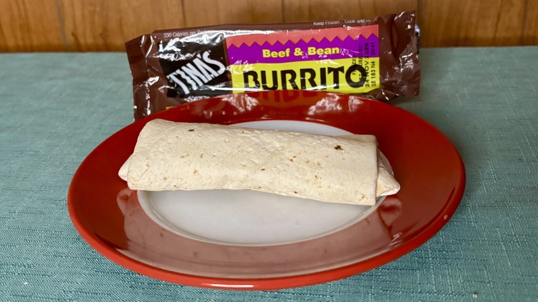 Tina's Beef & Bean burrito on a red plate, in front of the burrito's packaging