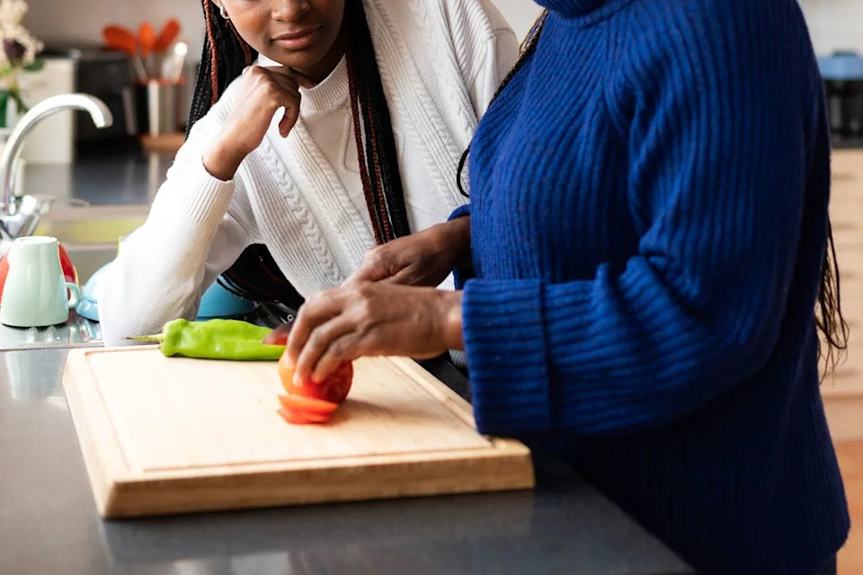 Getty Stock image of a mom showing teen how to cook.