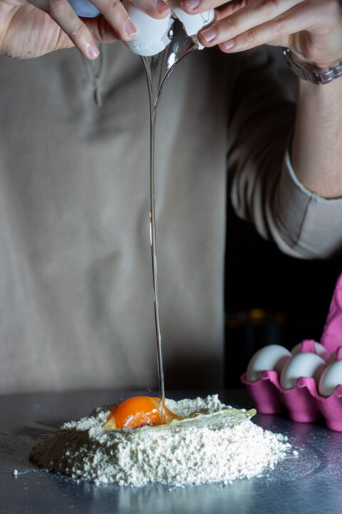 PASTA DOUGH: The egg is cracked in the middle of the flour vulcano.