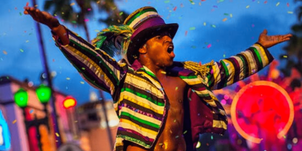A mardi gras dancer in a sequined jacket hypes up the crowd.
