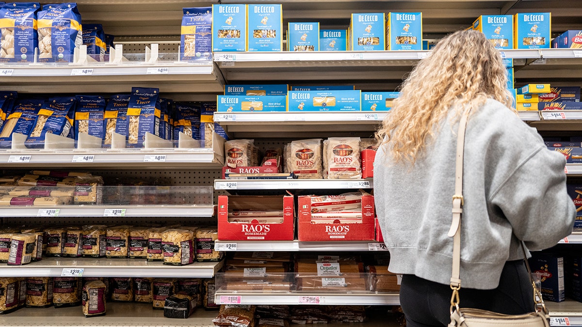 Woman shopping for pasta in grocery store in Texas.