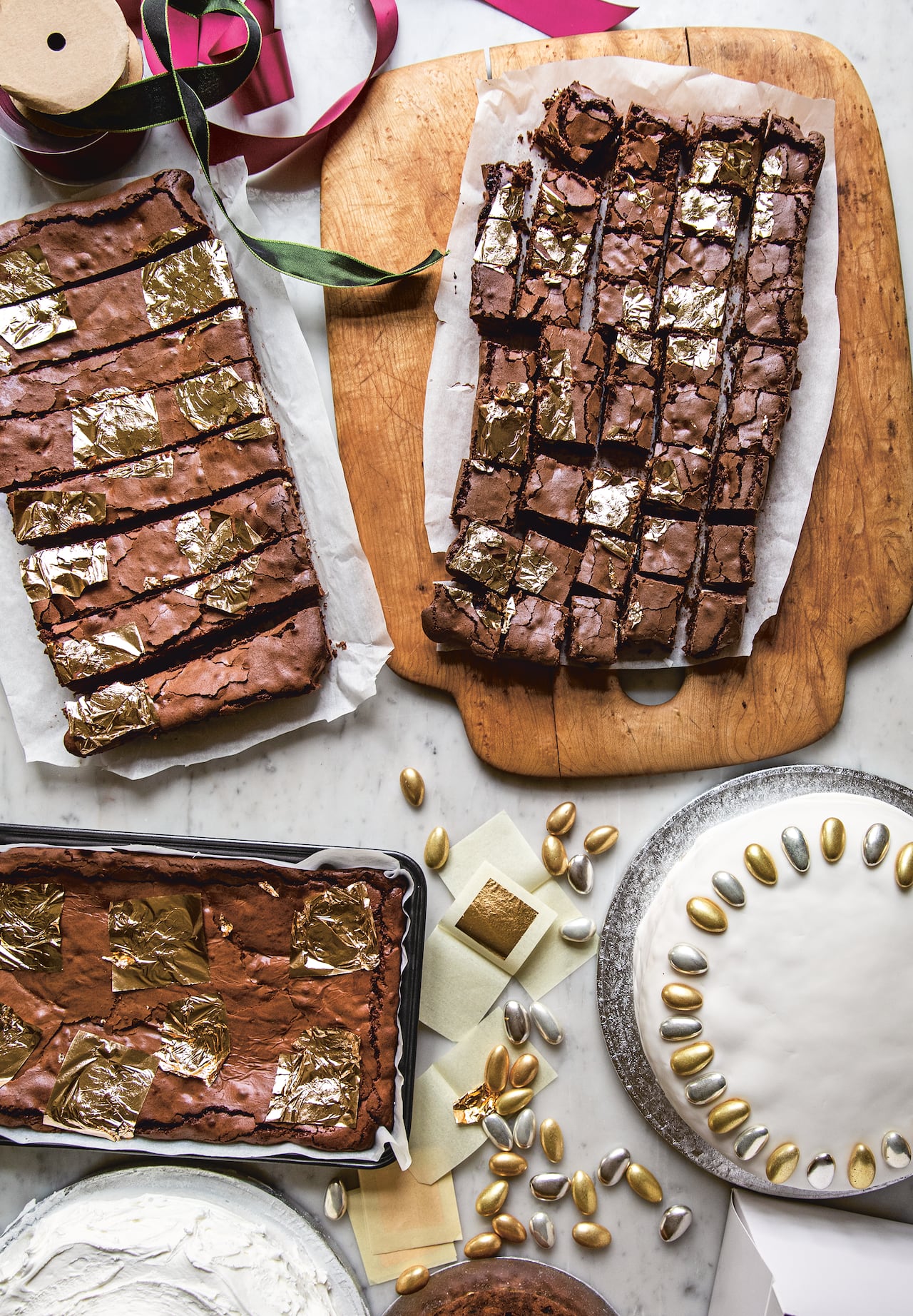 Top down shot of 3 batches of brownies with gold leaf on them. 