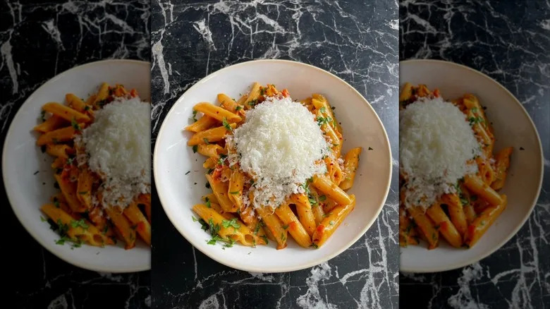 Bowl of pasta heavily topped with shredded parmesan