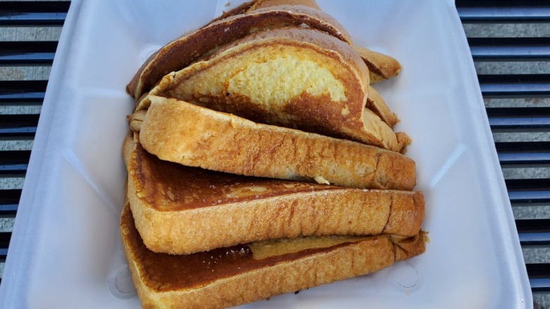 Slices of Another Broken Egg Café French toast in a white takeout box