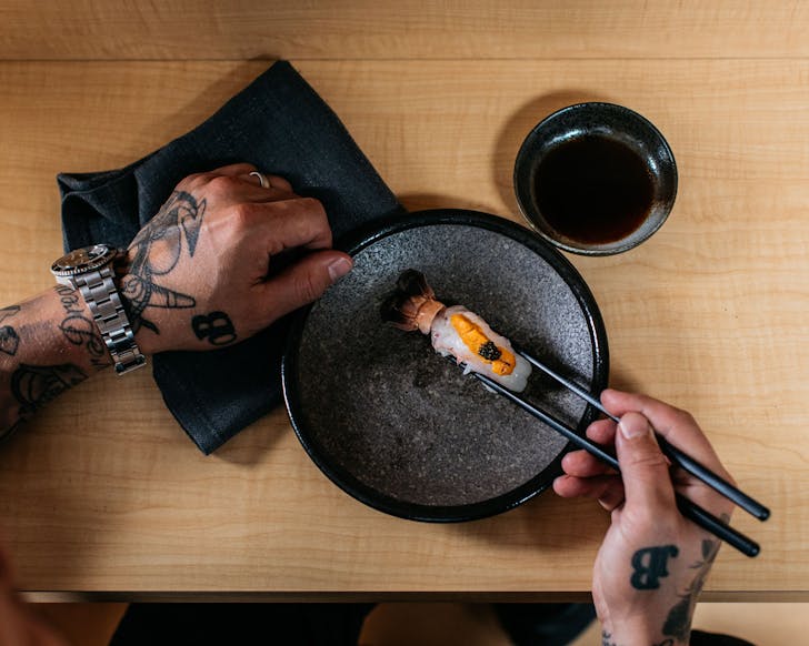 a chef plates an elegant nigiri at circular quay omakase restaurant besuto