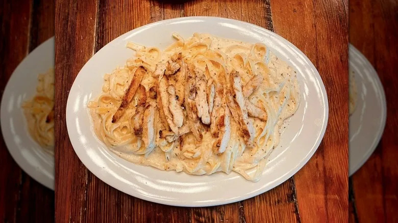 Fettuccine in creamy white sauce with chicken on top