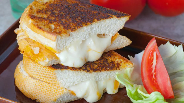 A sliced grilled cheese on sourdough with a blend of cheeses.