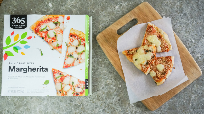 365 by Whole Foods Market Thin Crust Pizza Margherita next to slices on cutting board
