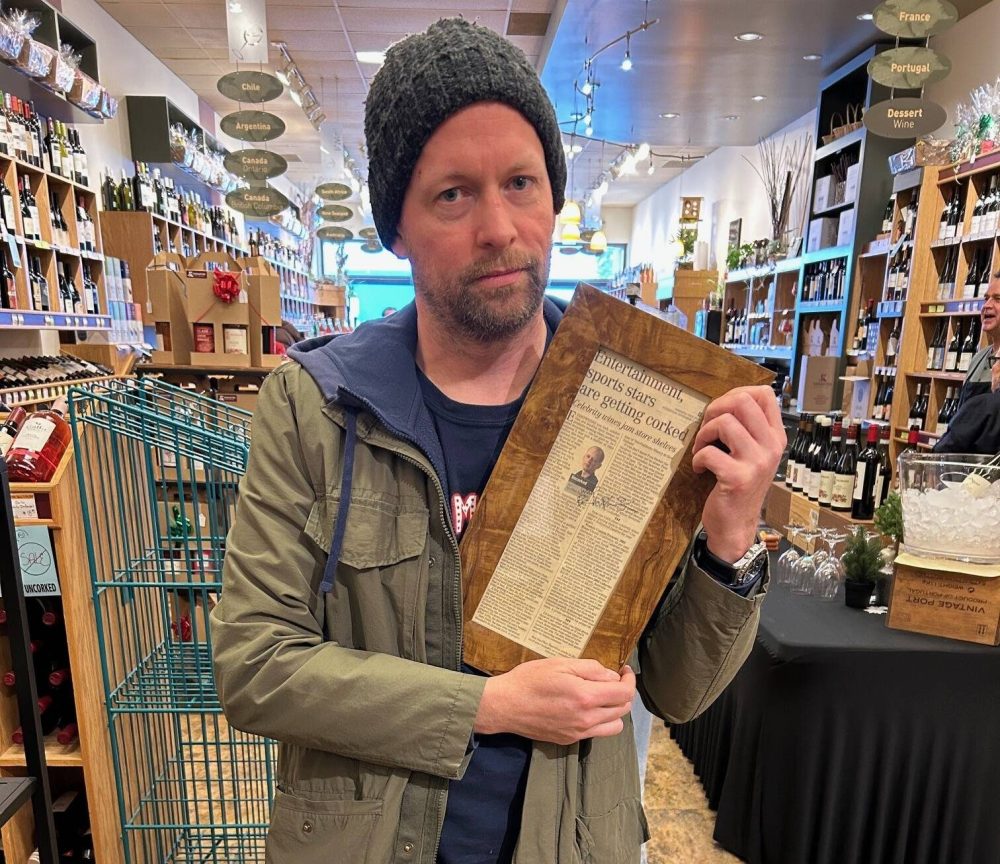 Supplied
Ben Sigurdson holds a framed copy of his first Uncorked column at Kenaston Wine Market.