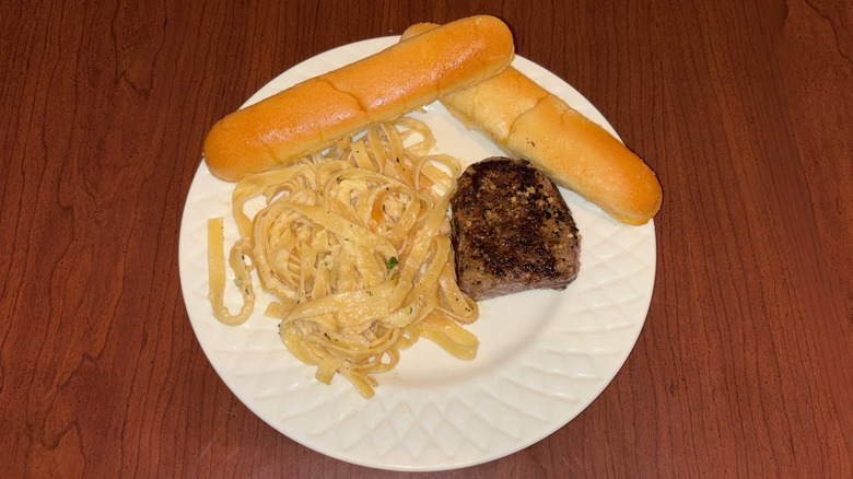 6-ounce sirloin with fettuccini alfredo and breadsticks.