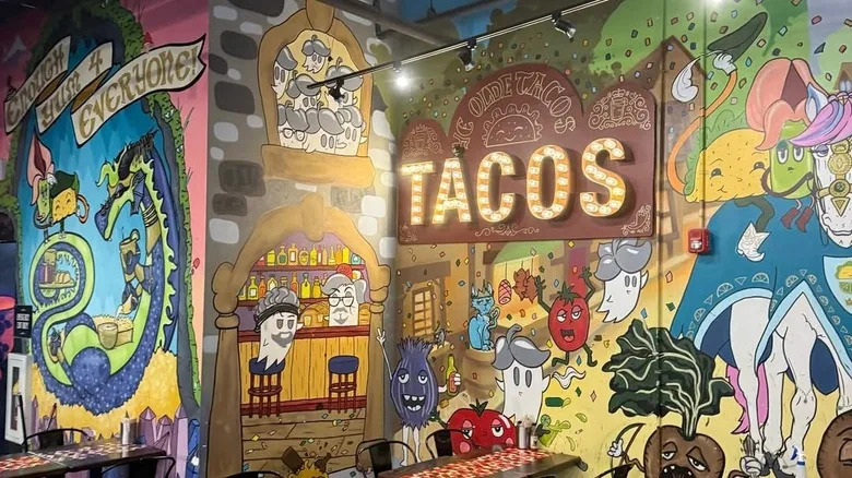 Condado Tacos' colorful interior, designed with quirky murals, complete with an illuminated sign that says 