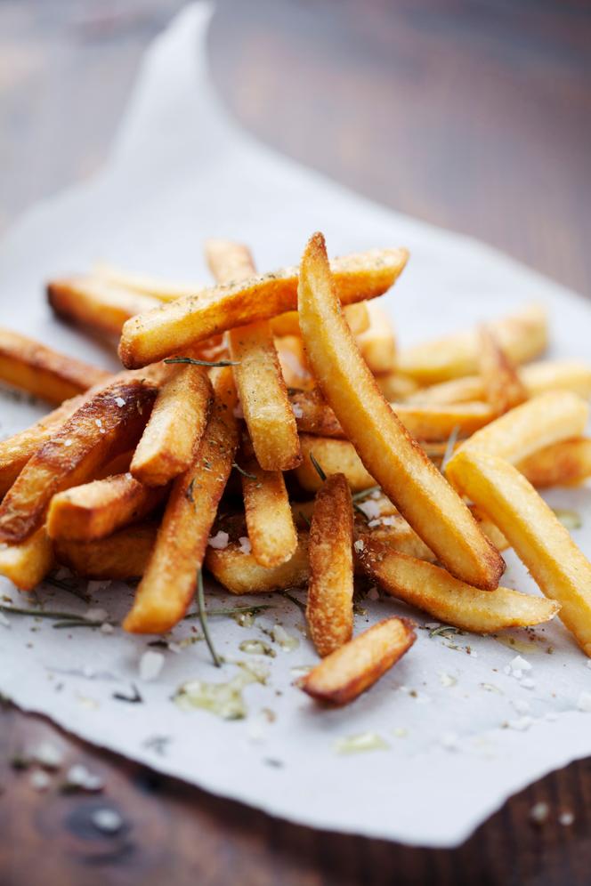 Fries garnished with salt and aromatic herbs.