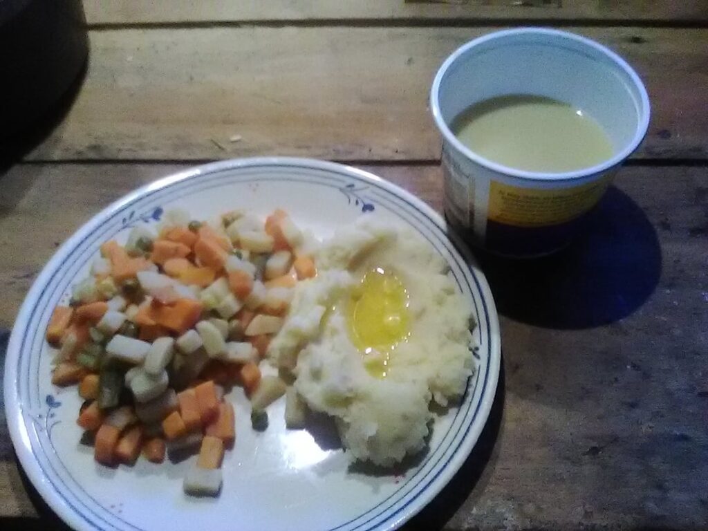 Yesterday's ration. Canned mixed vegatables, powdered mash potatoes with butter topping, and a cup of bulk butterscotch pudding