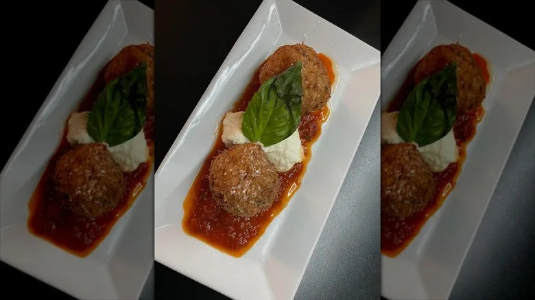 Two meatballs with burrata in between