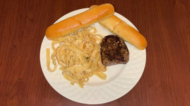6-ounce sirloin with fettuccini alfredo and breadsticks.