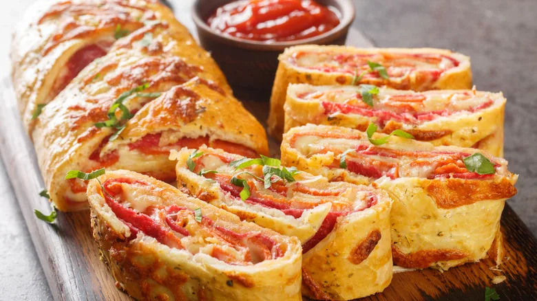 A close up of a sliced stromboli with pepperoni and cheese