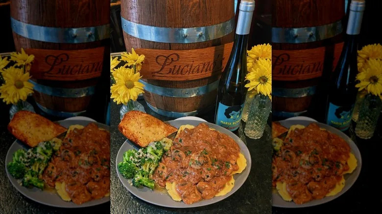 Ravioli topped with red sauce with broccoli and toasted bread on side
