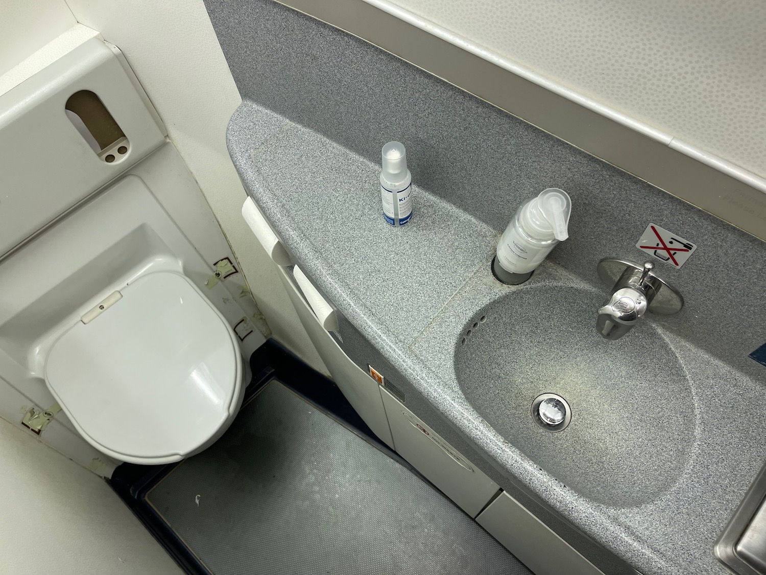 Aircraft lavatory interior featuring a toilet and sink with hygiene products, relevant to Air France 777-300ER Economy Class review.