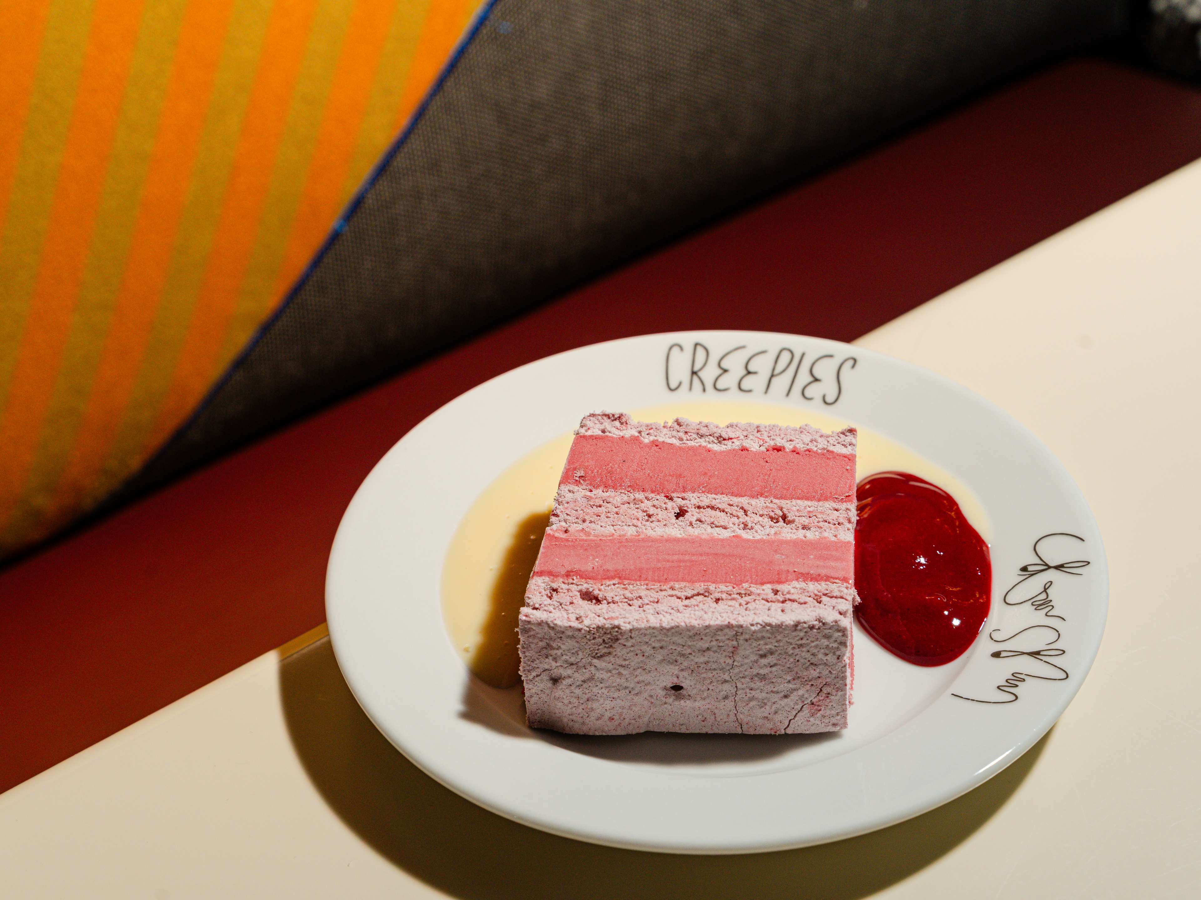 A plate with a slice of raspberry meringue cake.