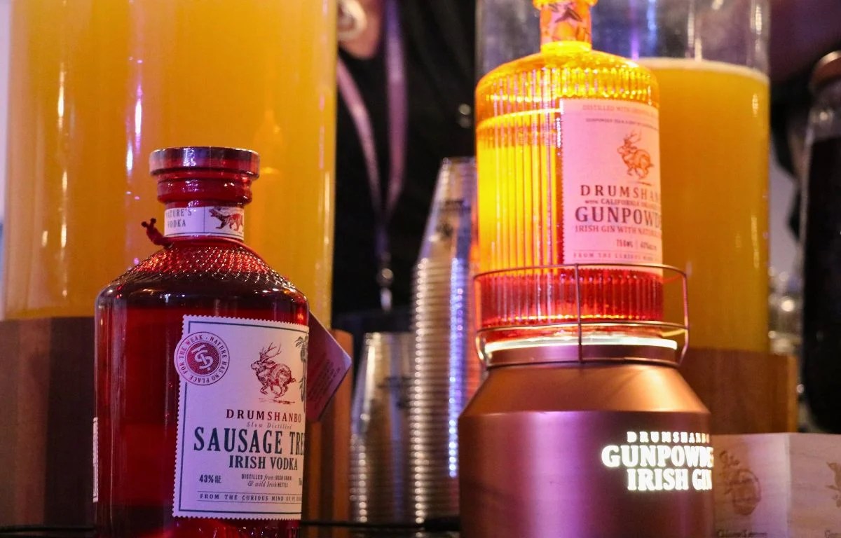 Bottles of Drumshanbo Gunpowder Irish Gin is displayed at a table.