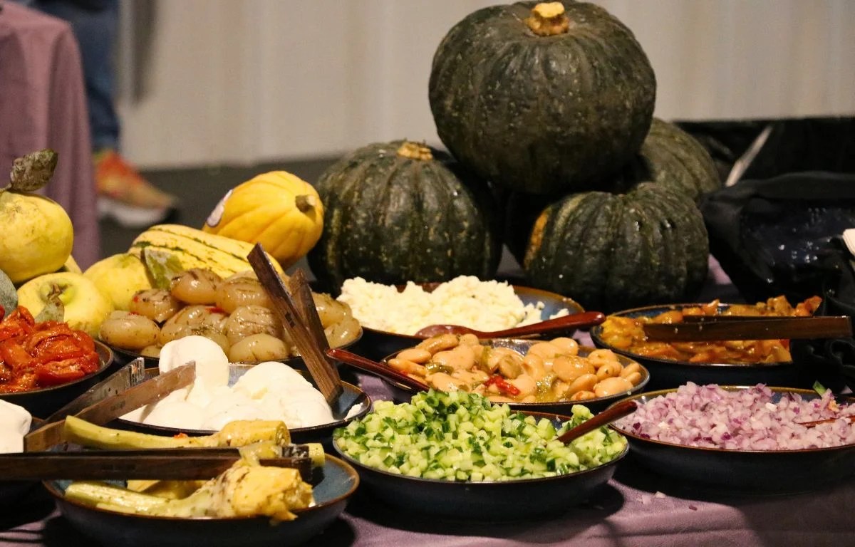 Gourds sit in the background with dishes laid out in front.