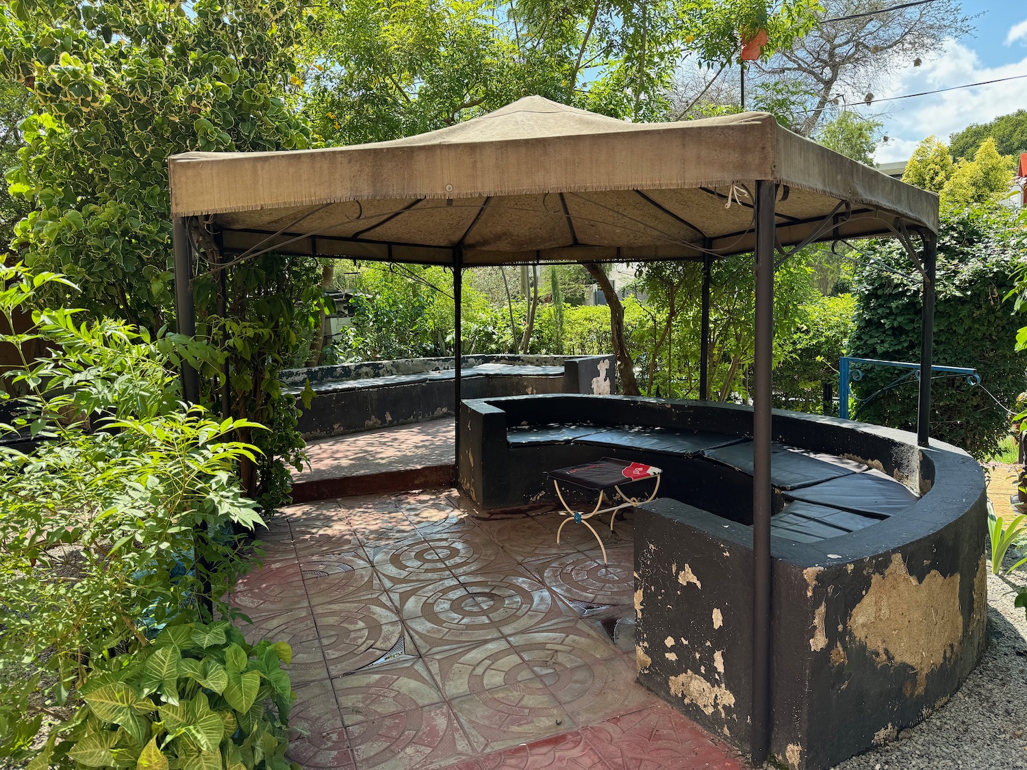 a covered patio with a bench and a table