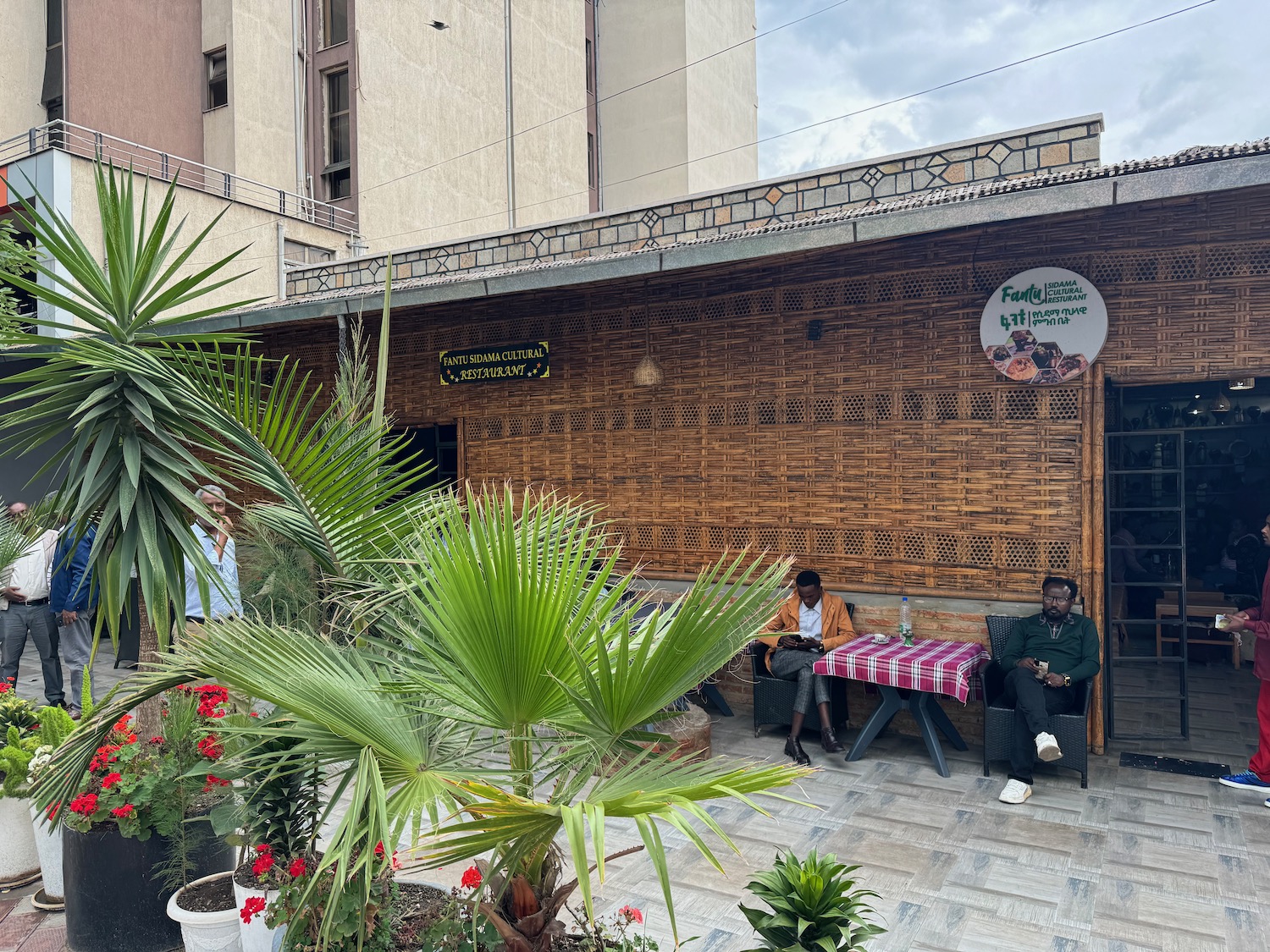 a man sitting on a bench outside of a building