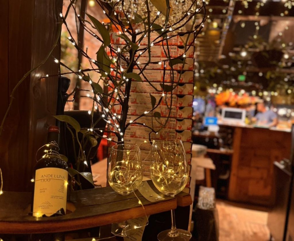 Twinkling lights around a bottle of wine and glasses at La Gitana