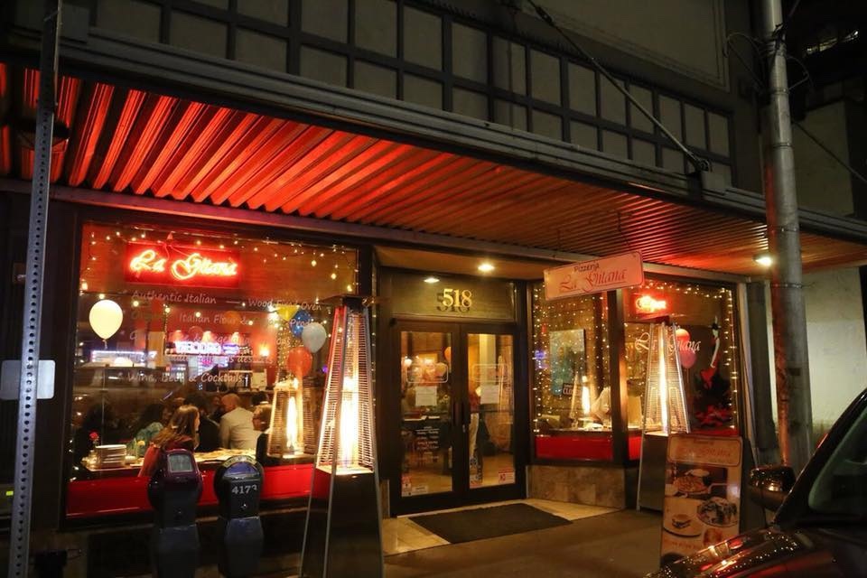 Outside of La Gitana Olympia at night with the lights on