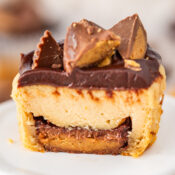 a Mini Peanut Butter Cup Cheesecake cut in half to show the Reese's Peanut Butter Cup on the bottom