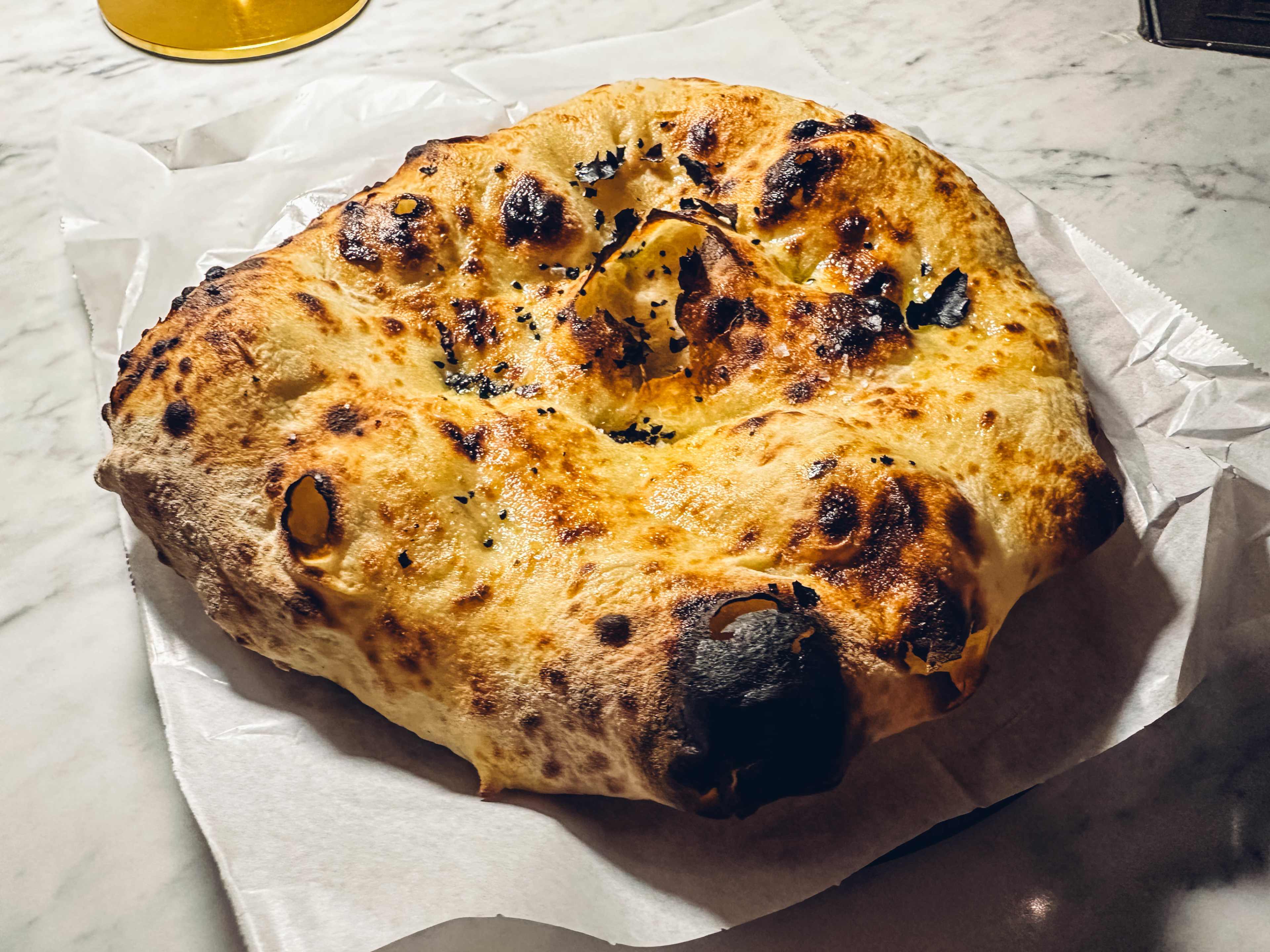 A charred and bubbly piece of laffa bread.