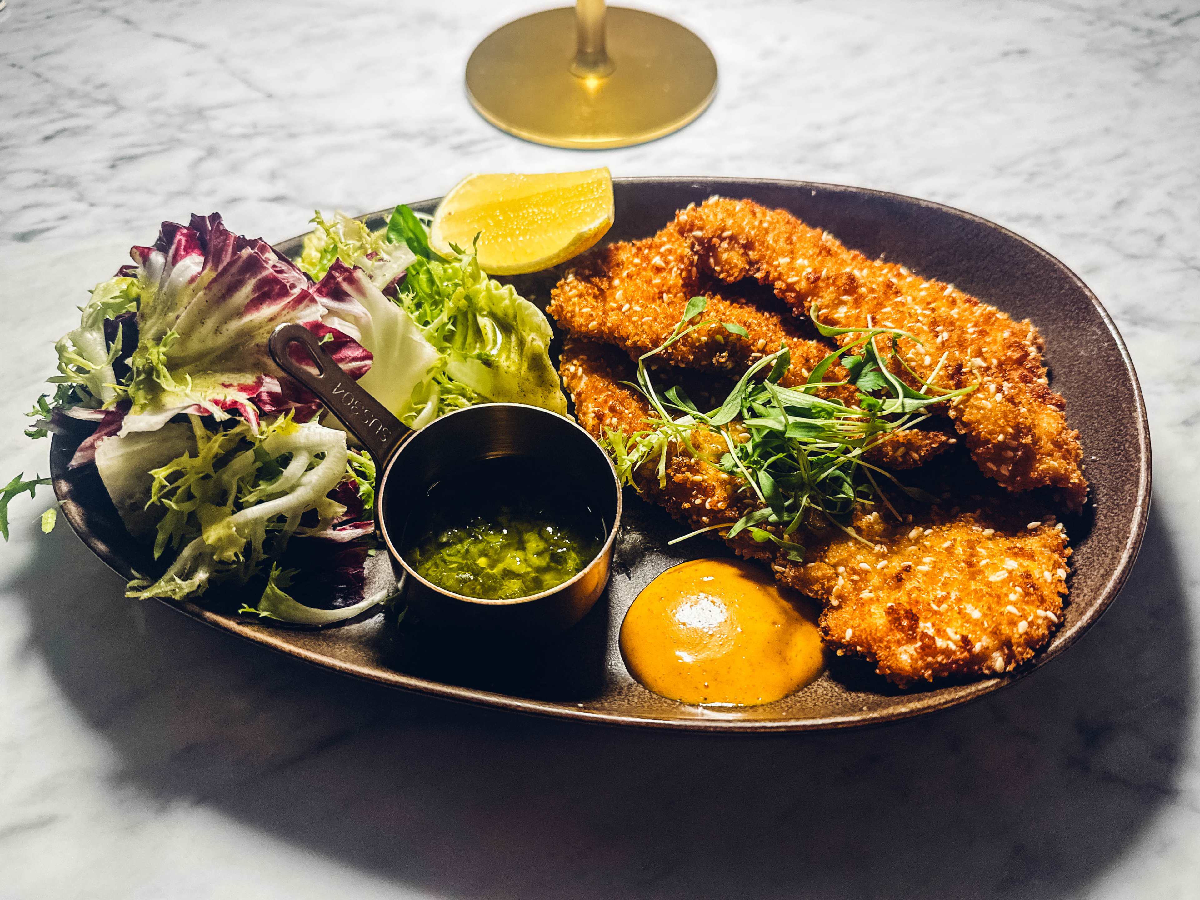 A plate with salad and chicken schnitzel.
