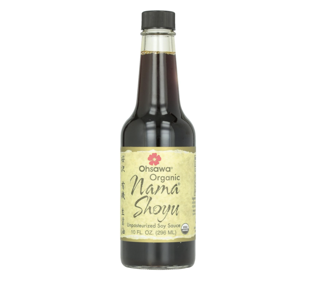 A bottle filled with brown liquid with a yellow label reading Ohsawa Organic Nama Shoyu Unpasteurized Soy Sauce.