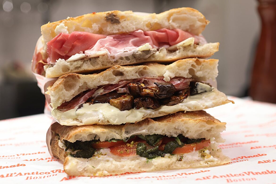 Three of All'Antico Vinaio's viral sandwiches (top to bottom):  La Schiacciata del Boss, with prosciutto Toscano, pecorino Toscano, and truffle cream; La Favolosa, with salame Toscana, pecorino cream, artichoke cream, and spicy eggplant; and La Genovese, with stracciatella, tomato, pesto, pistachio, and basil.