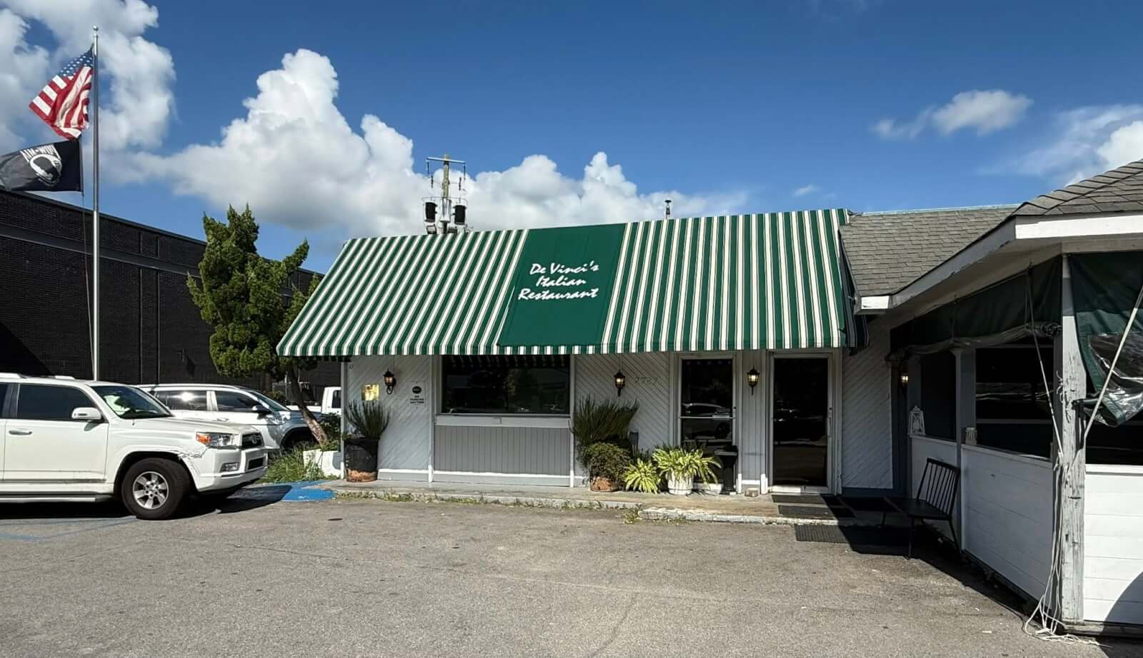 7 Beloved BHAM Restaurants We'll Miss - 1 A one-story restaurant with a green and white striped awning reading "Da Vinci's Italian Restaurant."
