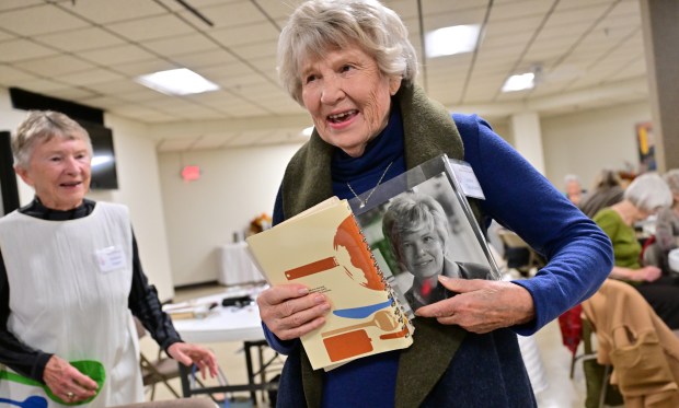 A woman holding copies of a cookbook