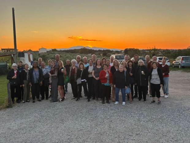 A group of people with a bright orange sunset behind them
