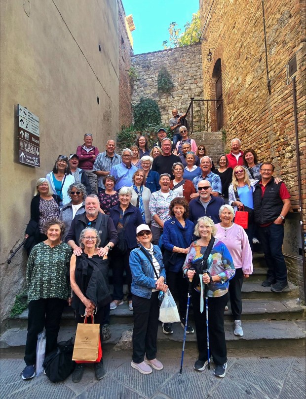 A group photo of smiling people on some medieval stairs