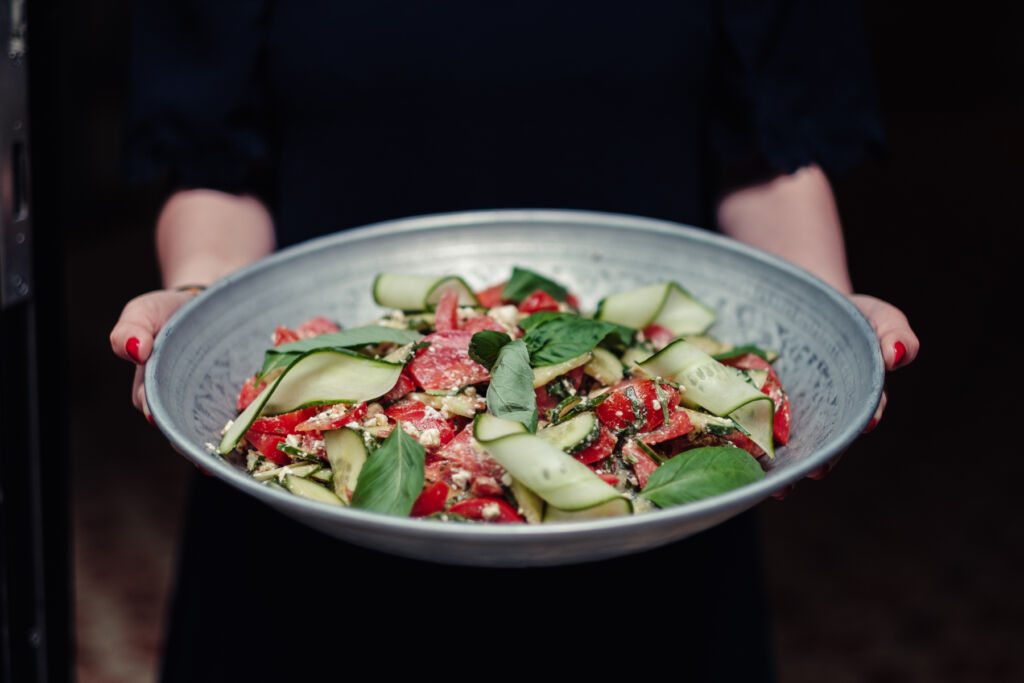 A member of staff bringing a salad dish