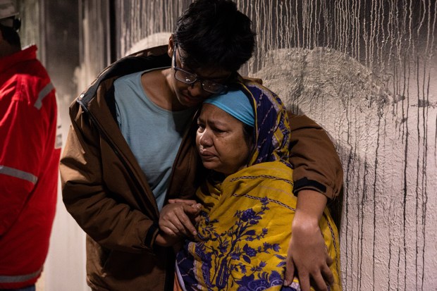 A young man comforting his grandmother after ten individuals were injured, two critically, from a fire on the third floor of a six story residential building at 1166 Grand Concourse in the Bronx, Tuesday, Nov. 4, 2025. (Shawn Inglima/ New York Daily News)