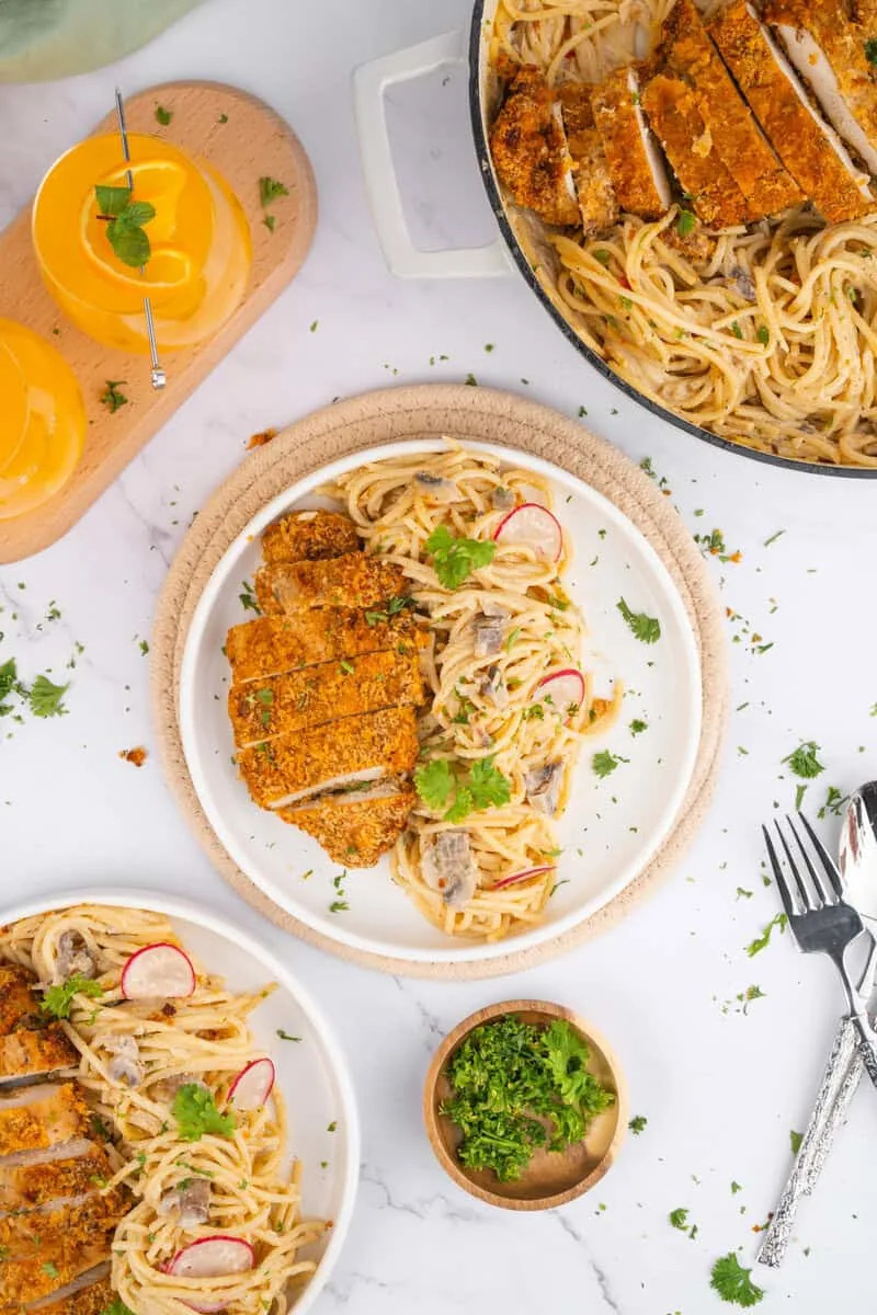Creamy pasta with crispy chicken on a plate.
