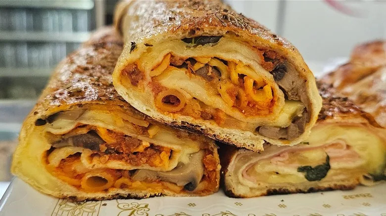 A close-up of homemade stromboli stuffed with cheese and pasta