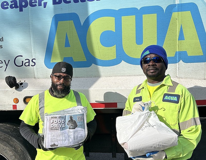 Rashawn Lymon and Adu Poku pick up non-perishable food items during a past ACUA Holiday Food Drive.