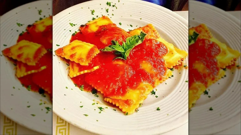Ravioli topped with red sauce and basil